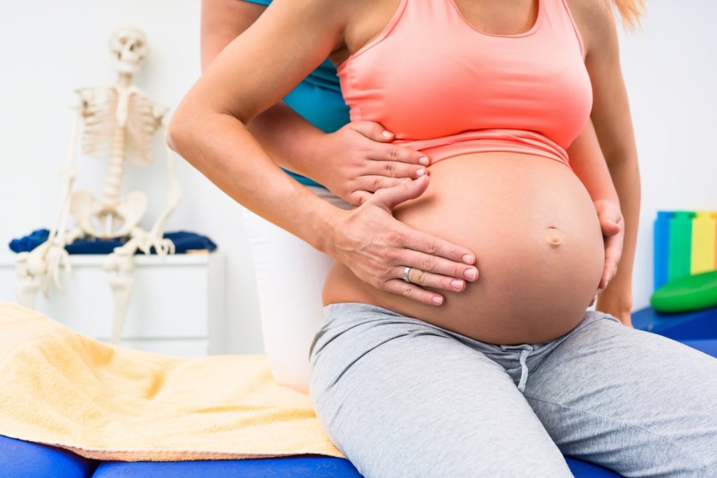 A therapist guiding a postpartum patient through exercises